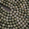 Close-up of green and white beads on a dark background