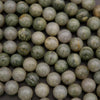 Close-up of green and beige marbled beads on a dark background