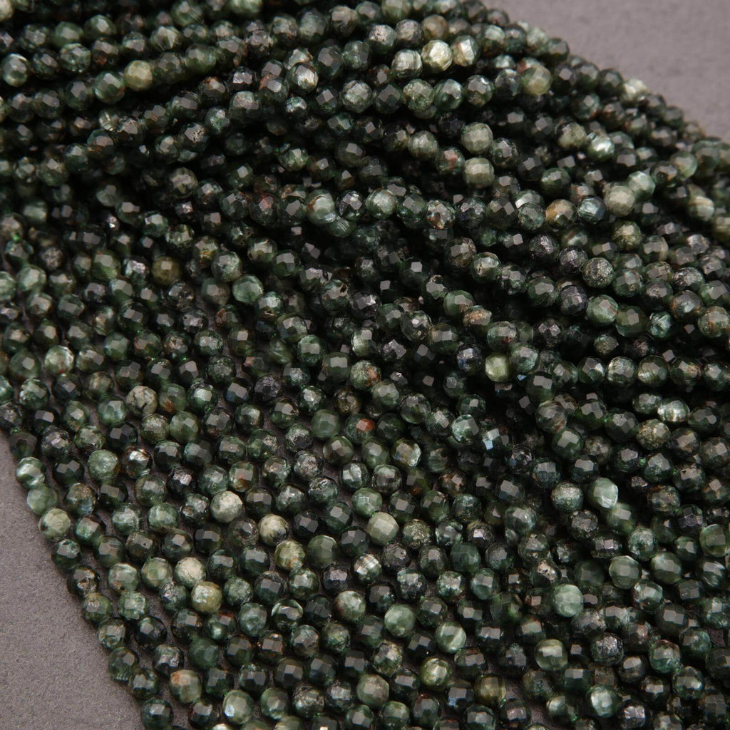Close-up of a string of green faceted beads on a gray background