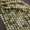 Close-up of green and white beads on a dark background