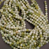 Close-up of a string of green and white beads on a gray background