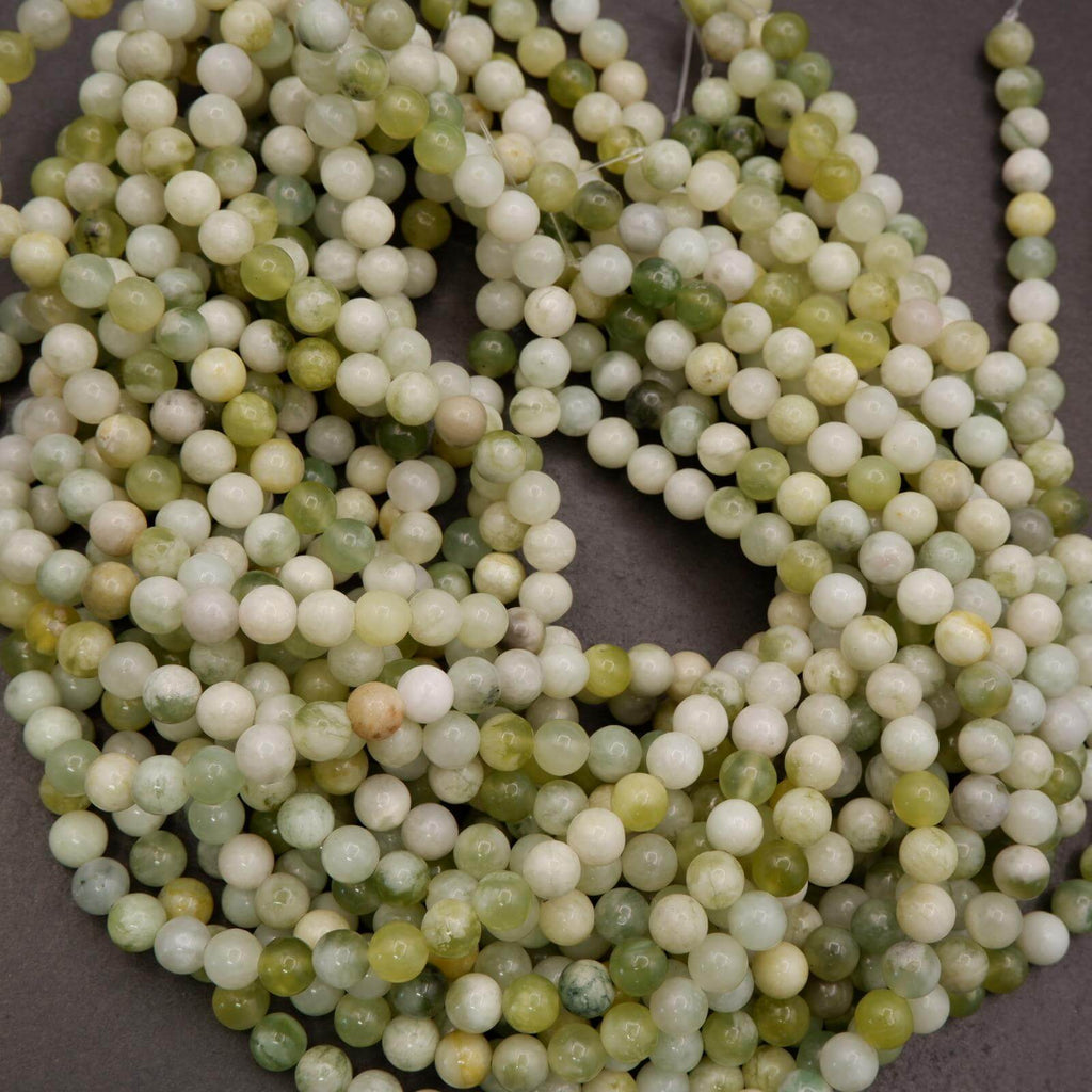 Close-up of a string of green and white beads on a gray background
