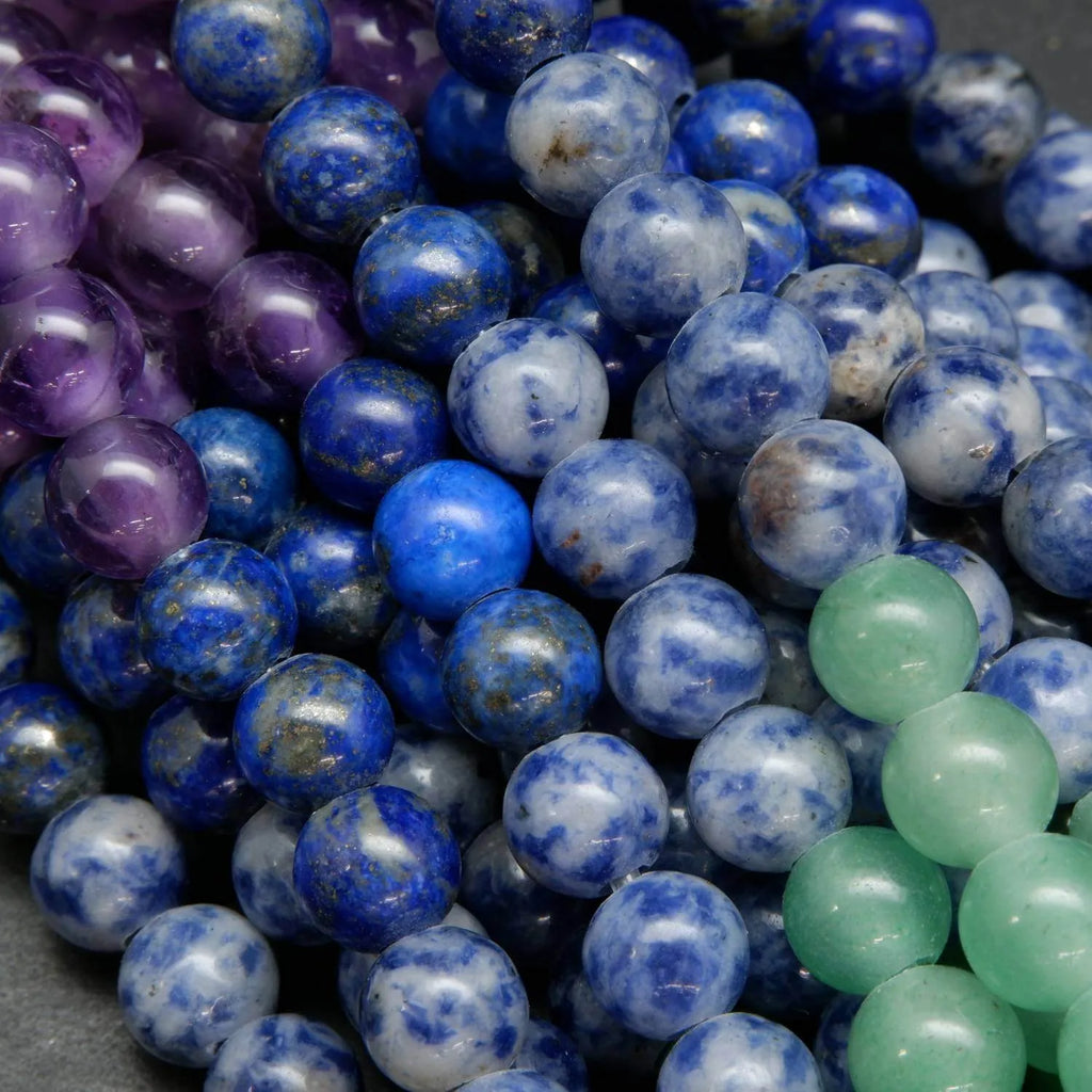 Close-up of blue, purple, and green beads on a dark background