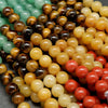 Close-up of multicolored round beads including green, brown, yellow, and red.