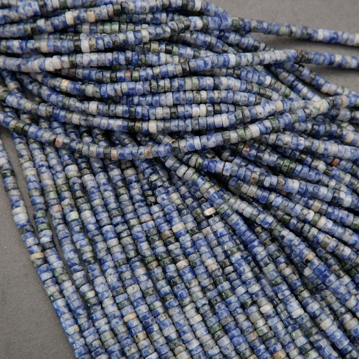 Assorted sodalite heishi bead strands arranged in overlapping rows on a neutral background.