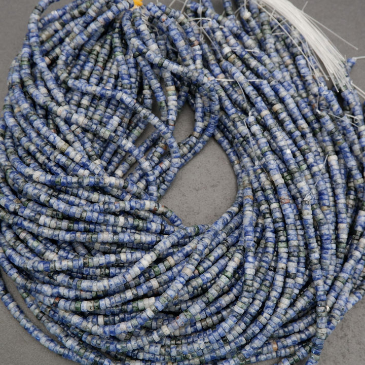 Detailed view of sodalite heishi bead strands with marbled blue and neutral stone patterning.