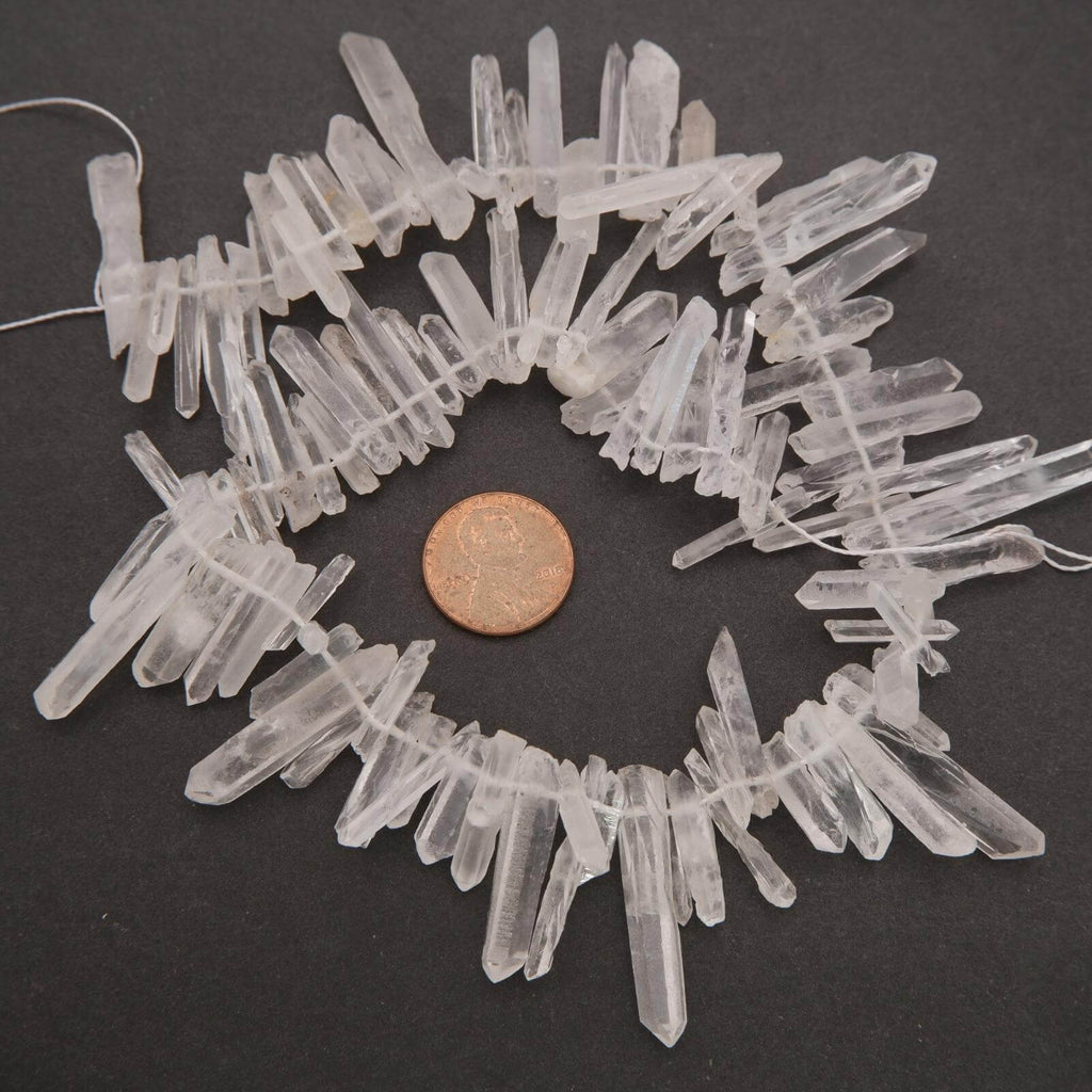 Crystal necklace with a penny for scale on a dark background