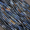 Close-up of blue and brown ceramic beads arranged in a pattern.