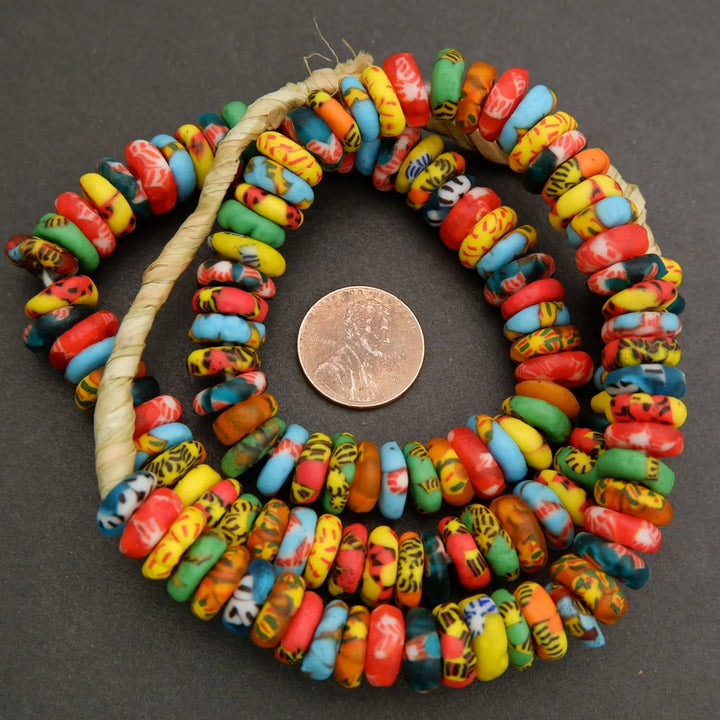 Colorful beaded necklace with a penny for scale on a dark background