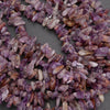 Close-up of purple and brown crystal chips on a dark surface