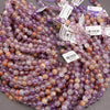 Close-up of purple and orange bead strands with labels on a gray background