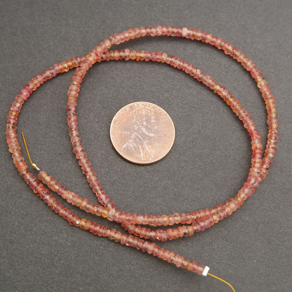 Beaded string with a penny for scale on a gray background