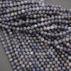 Close-up of purple faceted beads on a gray background