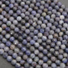 Close-up of purple and gray beads on a dark background