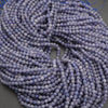 Close-up of a string of purple beads on a gray background