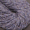Close-up of a skein of purple yarn on a gray background