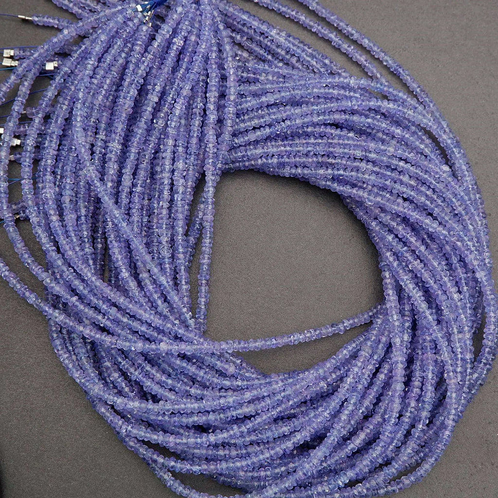 Coiled string of small purple beads on a gray background
