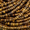Macro image of tiger’s eye disc beads highlighting silky chatoyancy and natural mineral patterns.