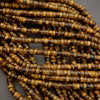 Natural tiger’s eye heishi beads with smooth polished finish and rich earth-tone coloration.