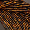 Close-up of brown and black beaded strands on a dark background