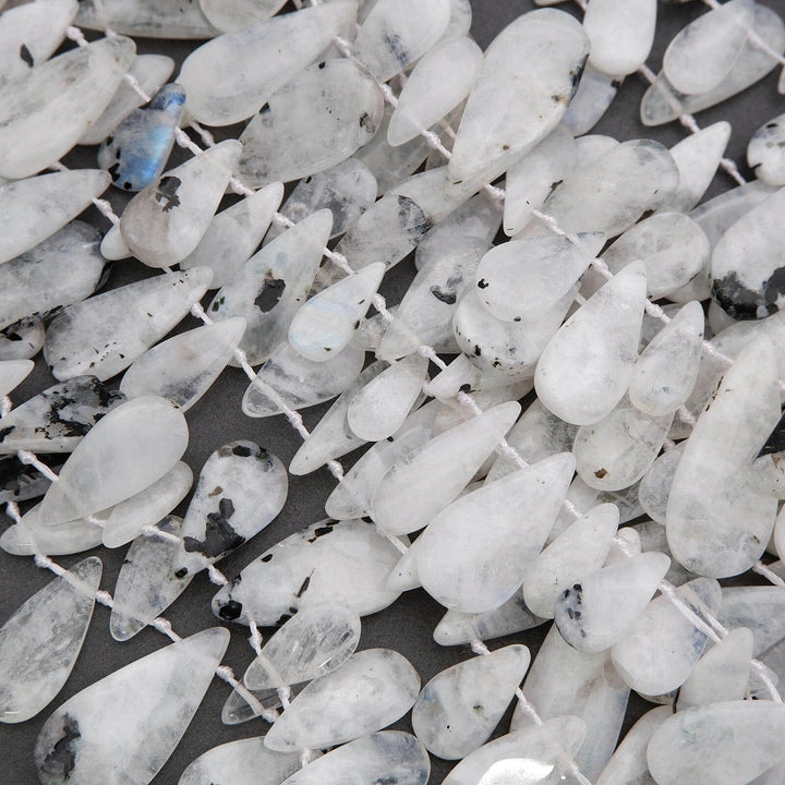 Close-up of white teardrop-shaped beads on a dark background