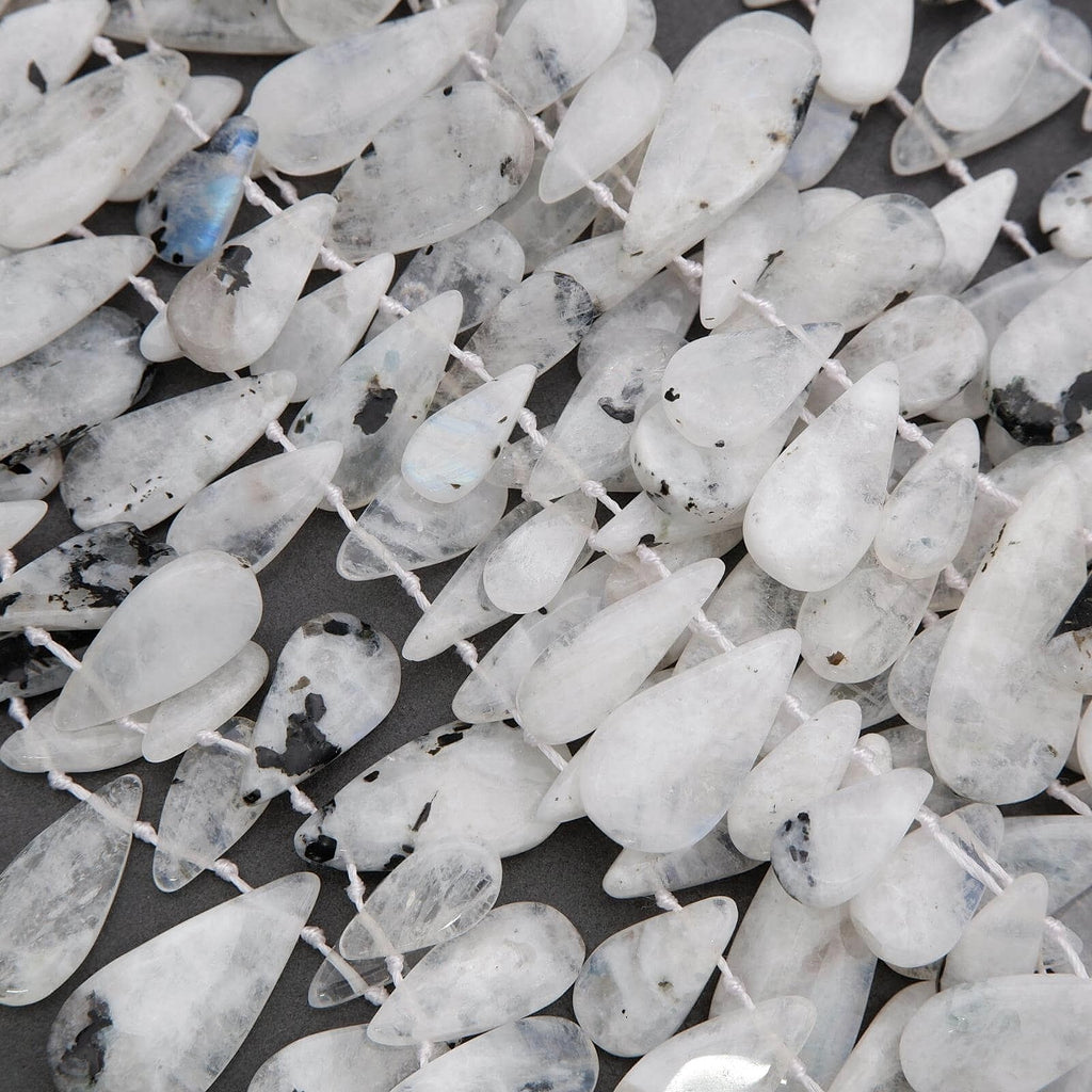 Close-up of white teardrop-shaped beads on a dark background