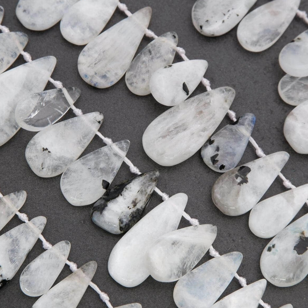 String of teardrop-shaped white beads on a dark background