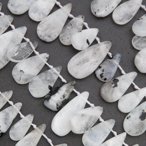 String of teardrop-shaped white beads on a dark background