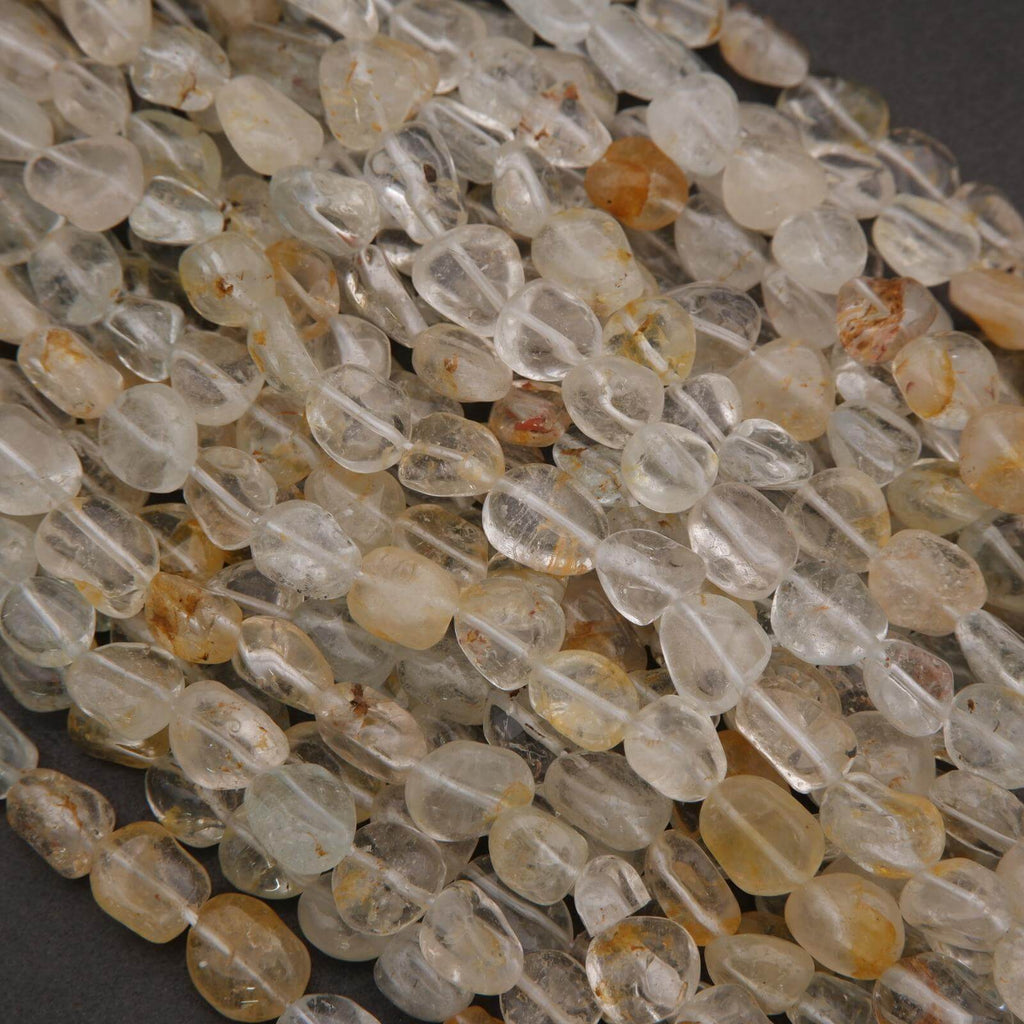 Close-up of clear and amber-colored beads on a dark surface