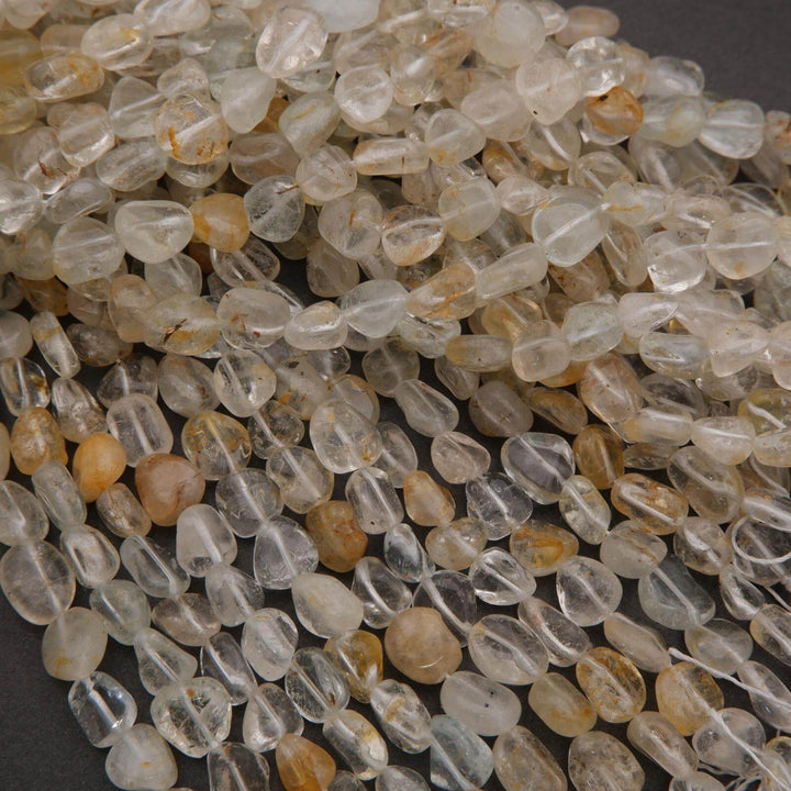 Close-up of clear and amber glass beads on a dark background