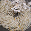 Close-up of a string of clear beads with small labels on a dark background