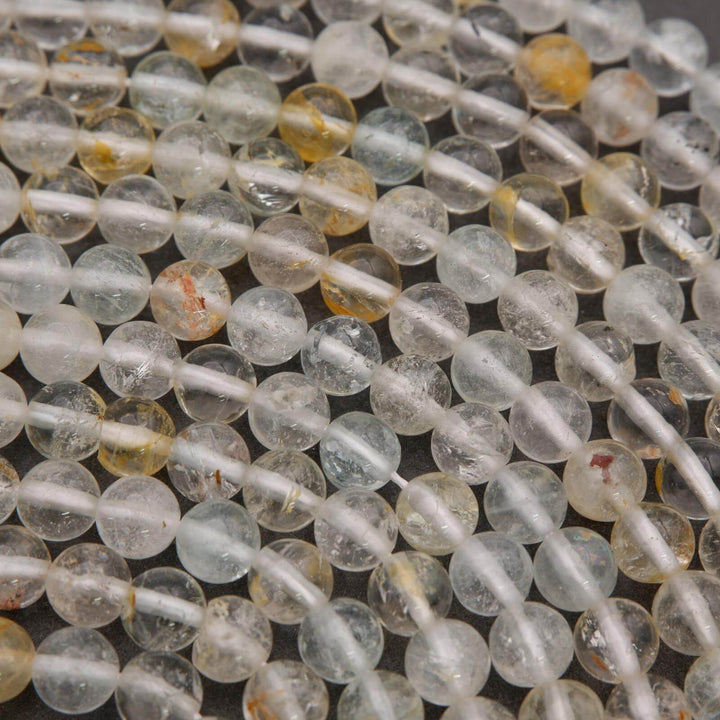 Close-up of transparent beads on a string with a dark background