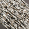 Close-up of small white and black beads on a string