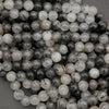 Close-up of round tourmalated quartz beads with dark tourmaline threads