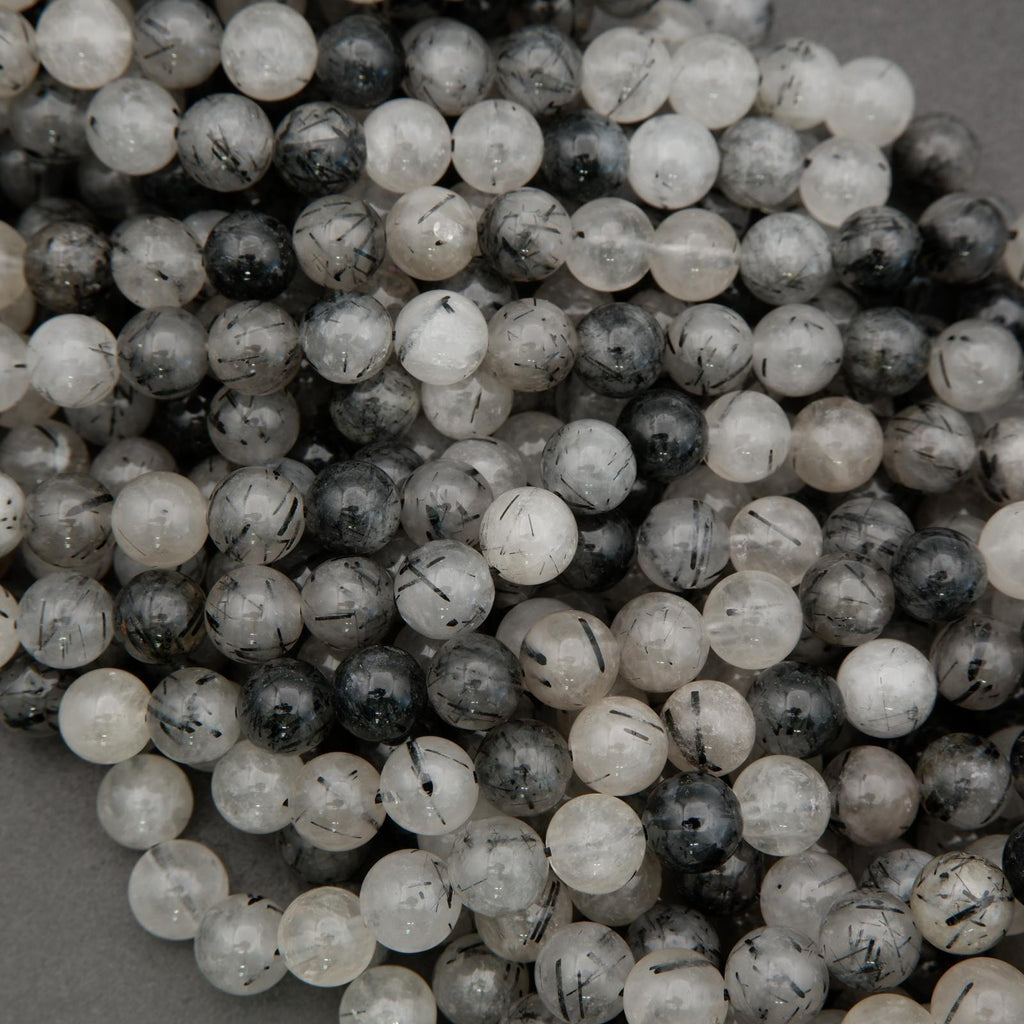 Close-up of round tourmalated quartz beads with dark tourmaline threads