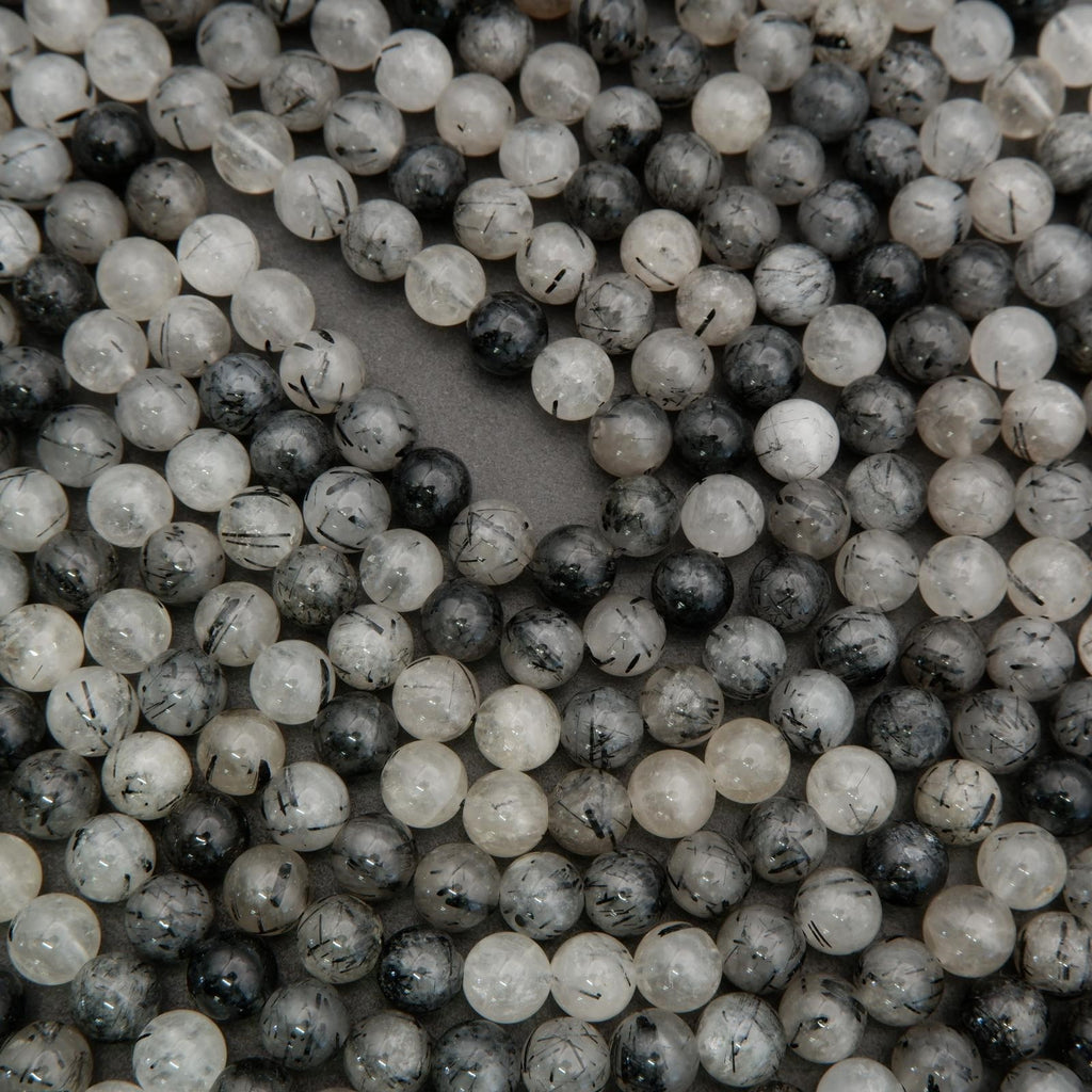 Detailed view of tourmalated quartz round beads with contrasting black needles