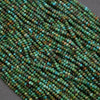 Close-up of a string of green and blue beads on a gray background