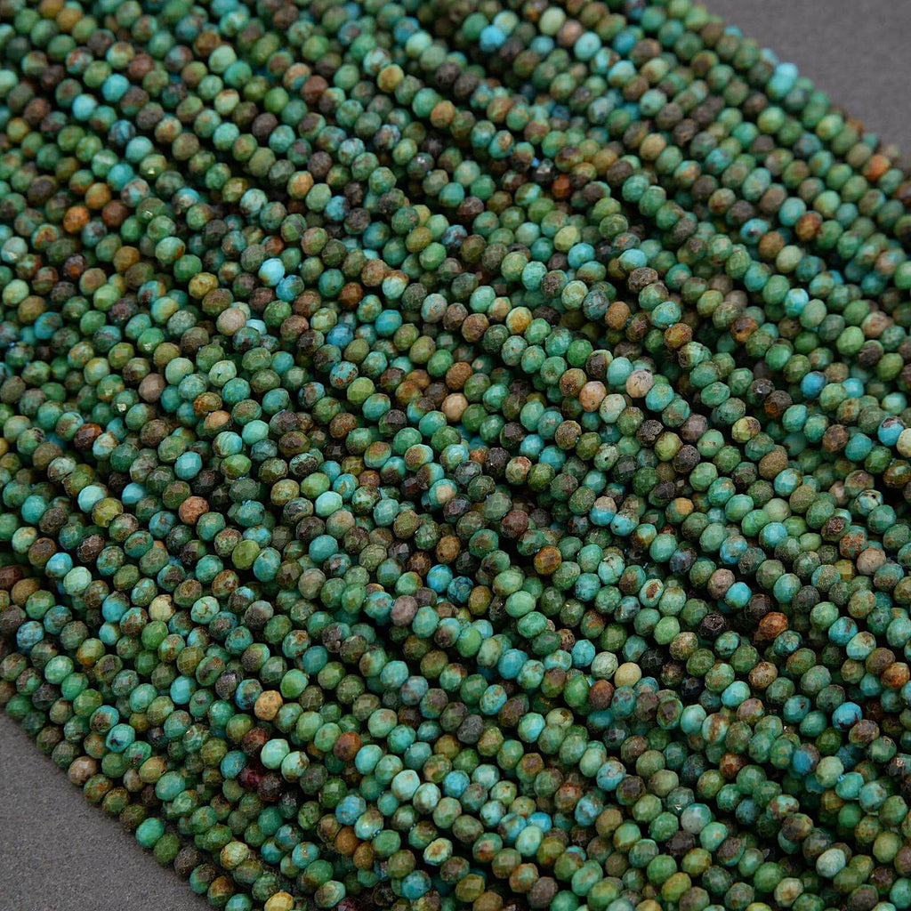 Close-up of a string of green and blue beads on a gray background