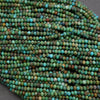 Close-up of a string of green and brown beads on a gray surface