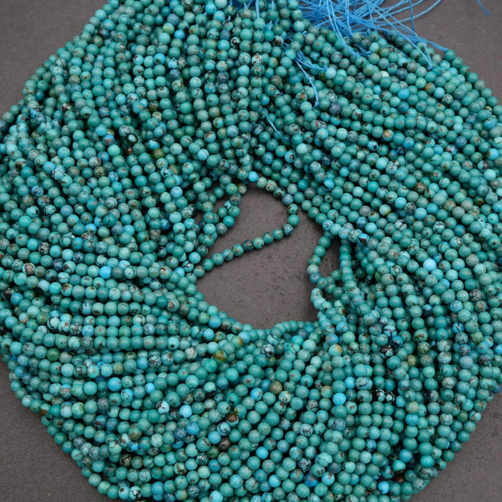 Turquoise beads on a string against a dark background