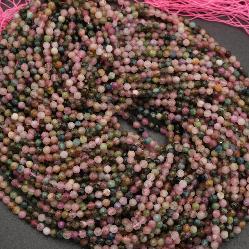 Multicolored bead string on a dark surface with pink thread in the background