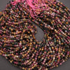 Multicolored bead string with pink thread on a gray background