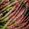 Close-up of multicolored beads in various shades of green, pink, and red.
