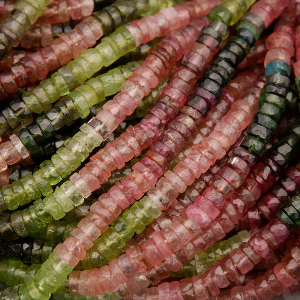 Close-up of multicolored beads in various shades of green, pink, and red.