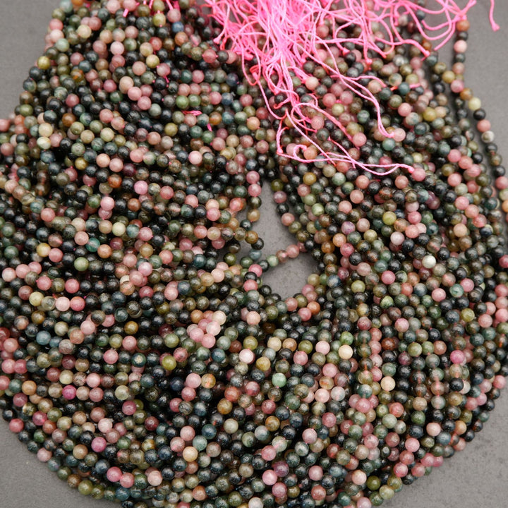 Multicolored bead string with pink tassels on a gray background