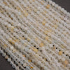 Close-up of a string of clear and beige beads on a dark surface