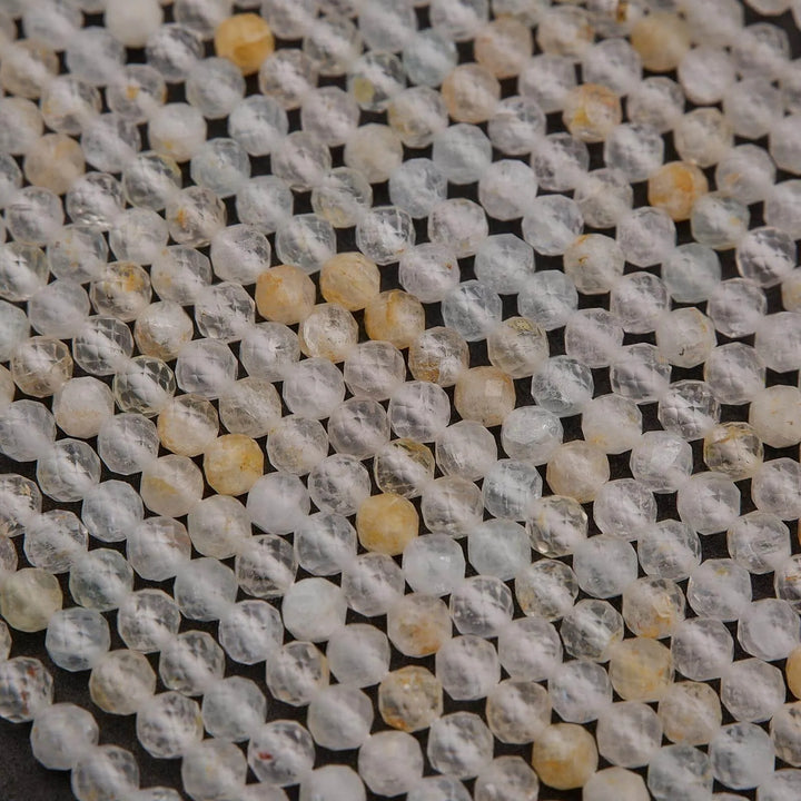 Close-up of clear and yellow beads on a textured surface