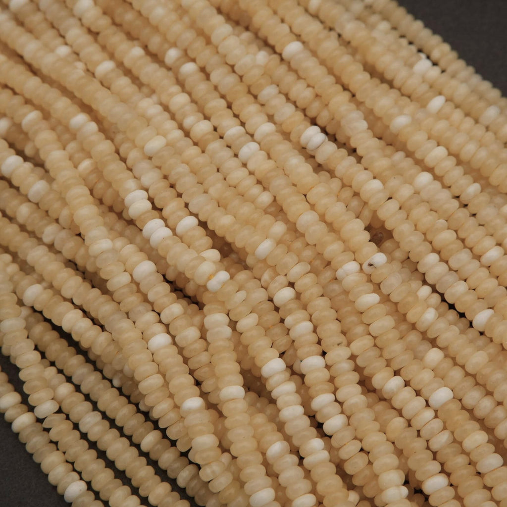 Close-up of beige glass beads on a dark background