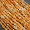 Close-up of small orange and white beads on a dark background