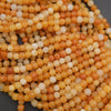 Close-up of orange and white seed beads on a dark background